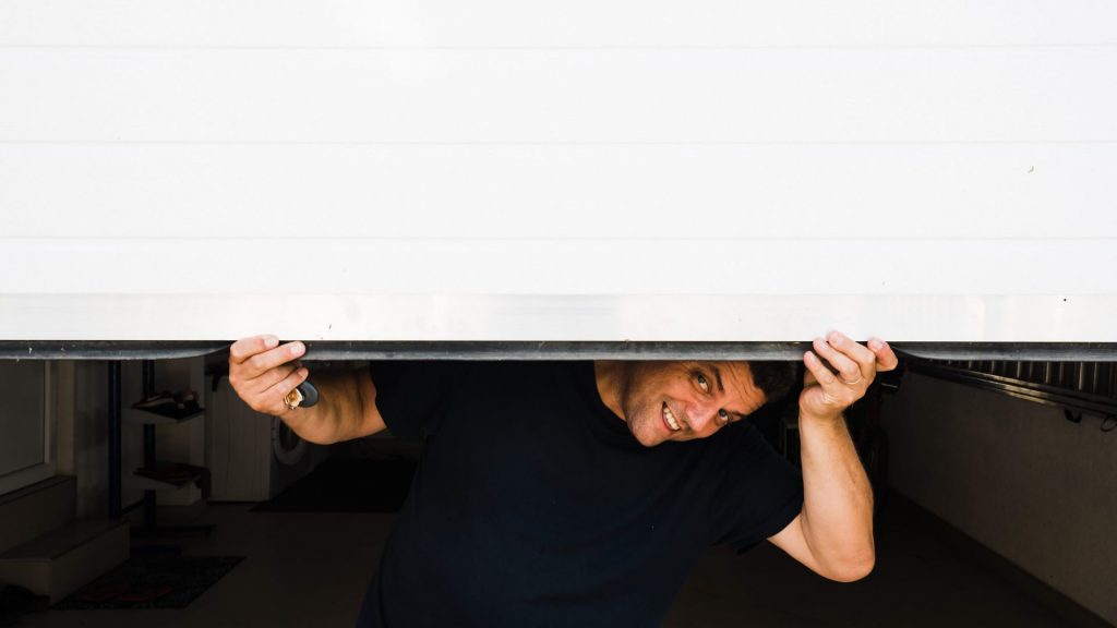 A man gets ready to perform garage door maintenance 